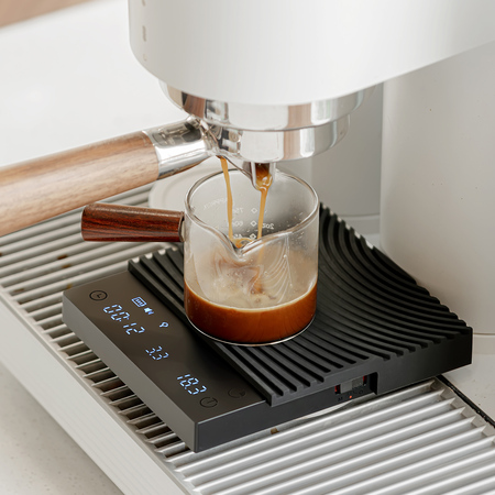 Timemore Black Mirror Basic 3 kahvivaaka 2 Timemore Black Mirror Basic 3 -vaaka espressokoneen alla, lasiin valuu espressoa